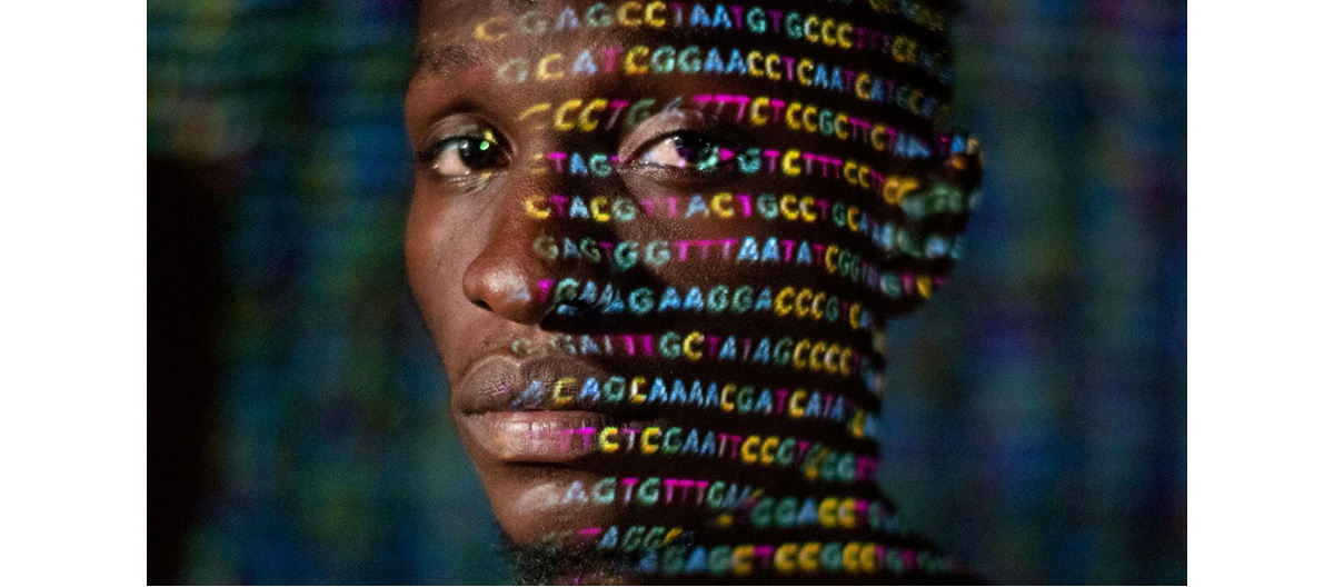 person with letters of DNA sequence projected on their face with light