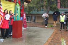 Professor Connie So and OCA representative speak to an audience on a rainy day in Seattle's Chinatown-International District