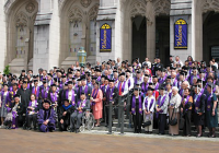 Former UW students from the Long Journey Home Ceremony stand on the steps of Suzzallo and Allen Libraries in graduation attire