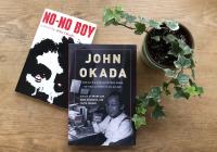 View from above of two books, NO-NO BOY and JOHN OKADA, next to a potted plant on a wooden tabletop
