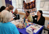 Jacque Waita and Kell Juan at the 2025 UW World Language Fair Jacque and Kell sit behind a table talking with students