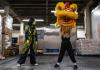 Tina Le, left, and Cooper Nguyen, right, take turns moving with the lion head at a Little Saigon grocery warehouse rented by the Mak Fai Kung Fu Dragon & Lion Dance Association in December