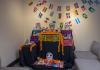 An ofrenda sits in the corner of the La Plaza room, adorned with photos, candles, and marigolds in honor of loved ones
